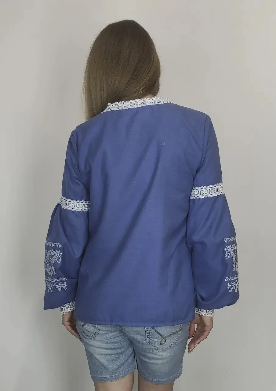 Traditional Ukrainian women's blouse decorated with white blue embroidery on blue homespun fabric
