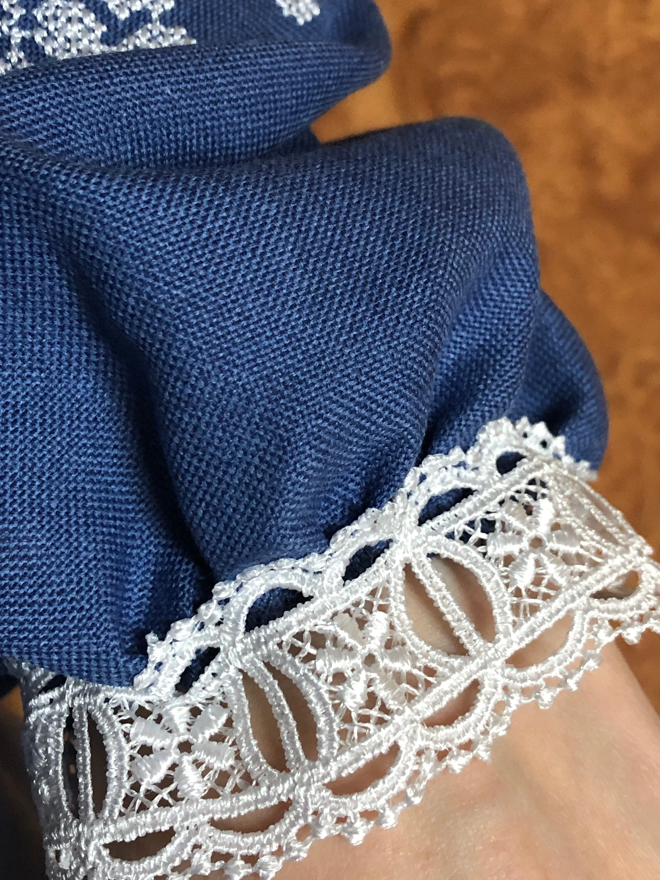 Traditional Ukrainian women's blouse decorated with white blue embroidery on blue homespun fabric