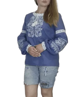 Traditional Ukrainian women's blouse decorated with white blue embroidery on blue homespun fabric