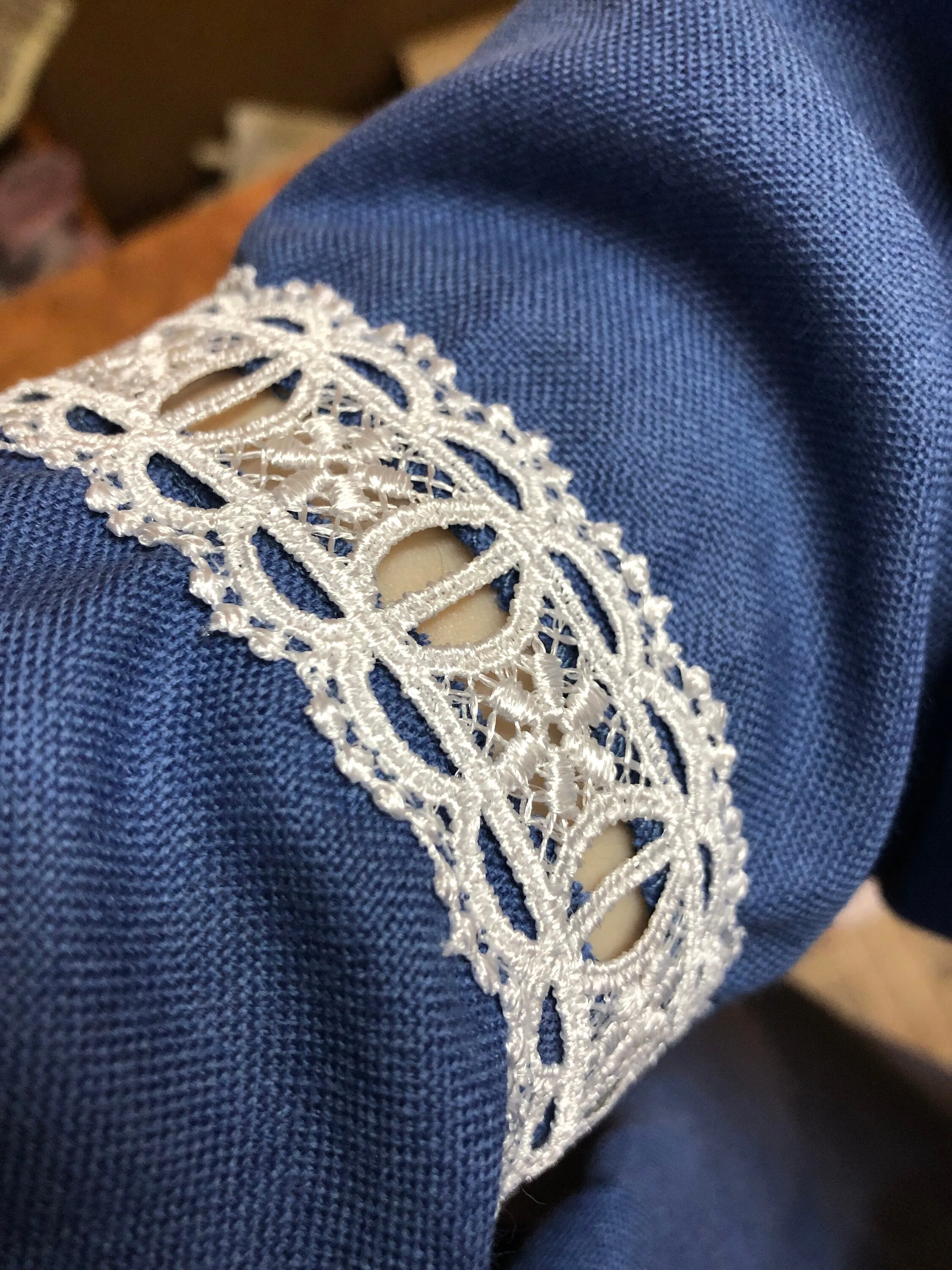 Traditional Ukrainian women's blouse decorated with white blue embroidery on blue homespun fabric