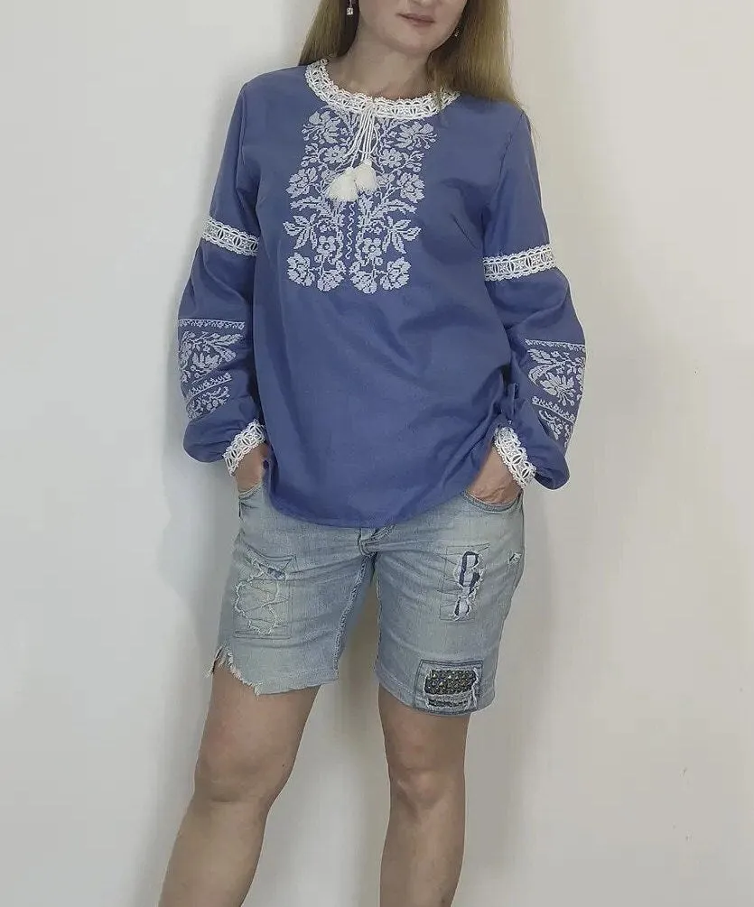 Traditional Ukrainian women's blouse decorated with white blue embroidery on blue homespun fabric