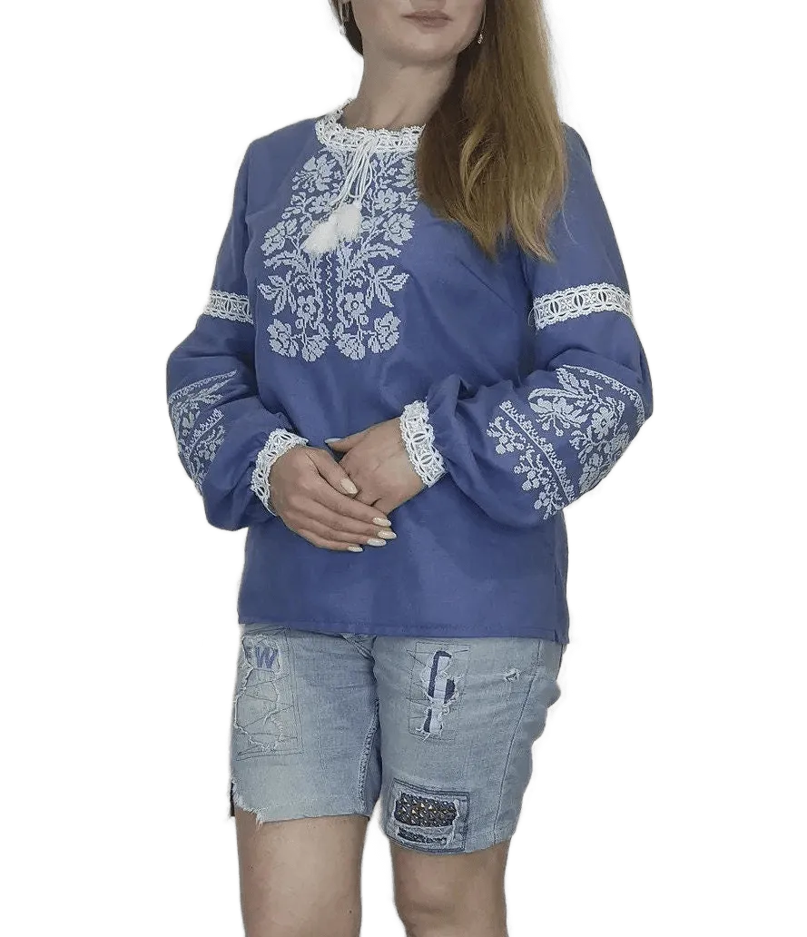 Traditional Ukrainian women's blouse decorated with white blue embroidery on blue homespun fabric