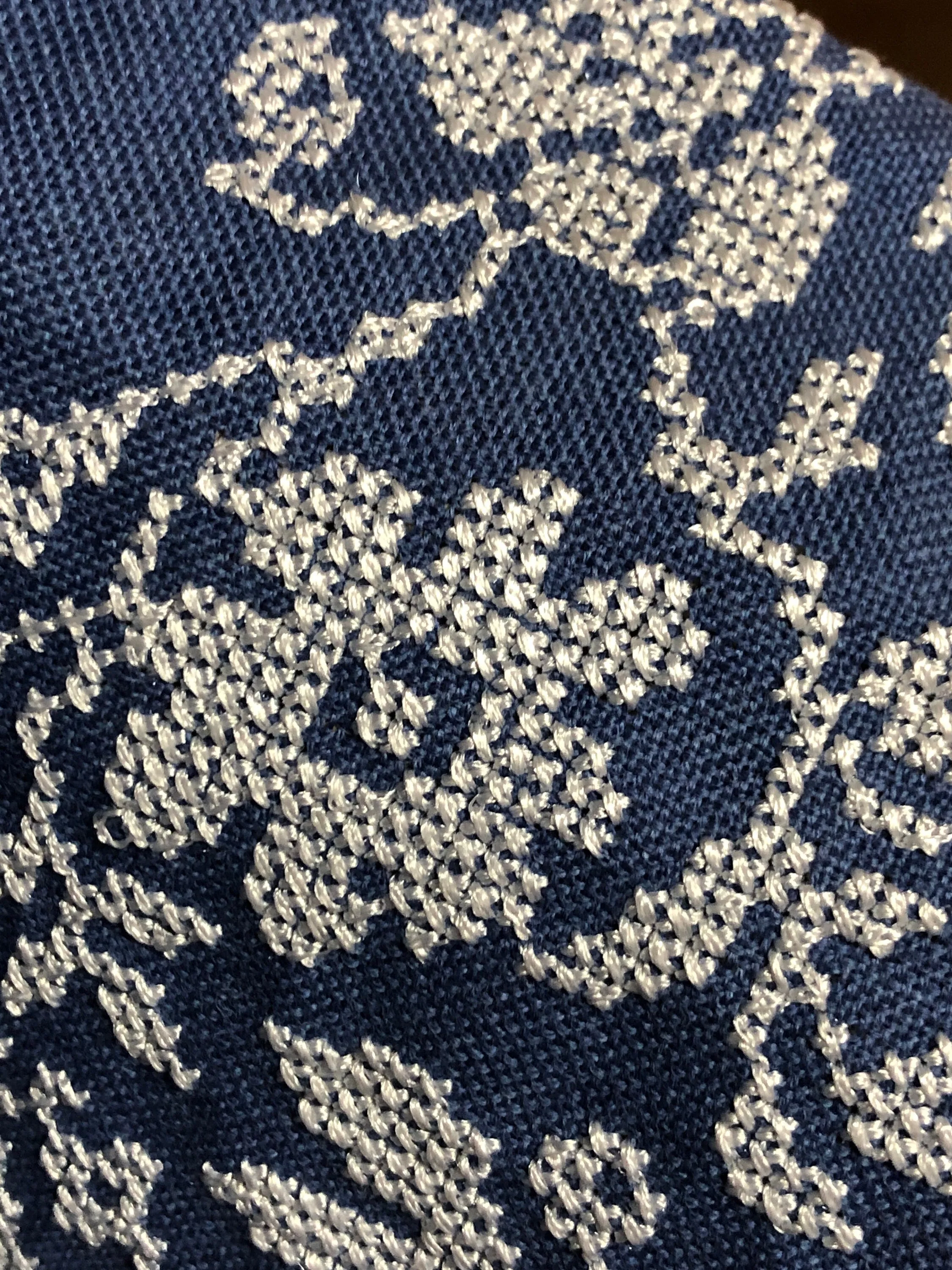 Traditional Ukrainian women's blouse decorated with white blue embroidery on blue homespun fabric